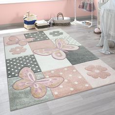 a child's room with pink and gray rugs on the floor next to a crib