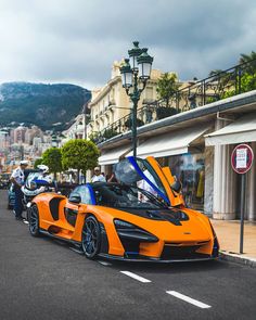 an orange sports car is parked on the street