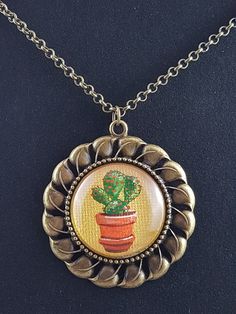 a necklace with a potted plant on it