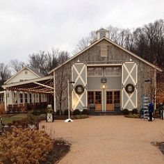 an old barn with wreaths and lights on the front