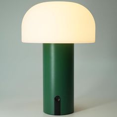 a green lamp sitting on top of a white table