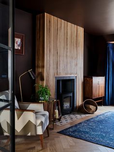 a living room filled with furniture and a fire place next to a wooden paneled wall