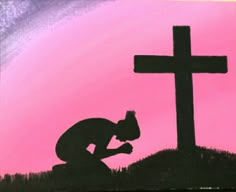 a man kneeling down in front of a cross