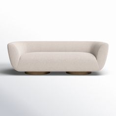 a white couch sitting on top of a wooden base