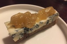 a piece of cheesecake with blue and white toppings on a plate, ready to be eaten