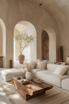 a living room filled with white furniture and lots of natural light coming in from the windows