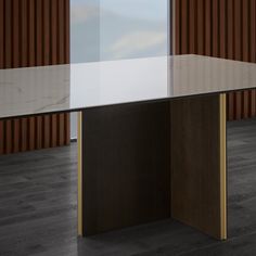 a glass table with a wooden base in front of a brown and white striped wall