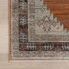 an area rug with various patterns and colors on top of a wooden flooring surface