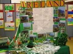 a table topped with lots of pictures covered in green and white paper next to a sign that says ireland