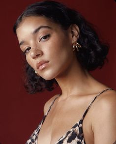 a woman with dark hair wearing gold earrings