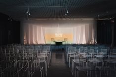 rows of chairs in front of a stage with the words blank space written on it