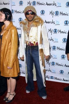 two people standing next to each other in front of a wall with music awards on it