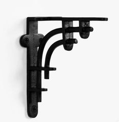 a black and white photo of a wall mounted coat rack with three hooks on it