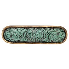 an ornate metal object with green and black designs on it's sides, against a white background