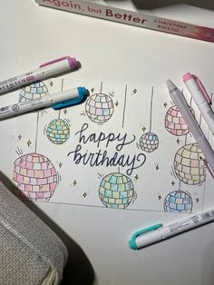 some pens are laying on top of a birthday card with disco balls and the words happy birthday