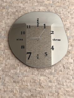 a clock that is on the side of a brick wall with numbers and times below it