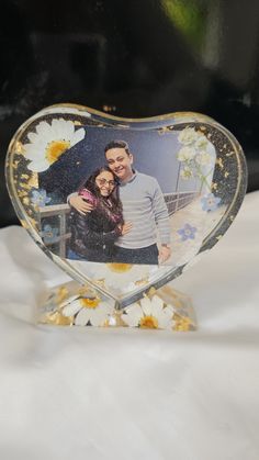 a heart shaped photo frame with flowers on it