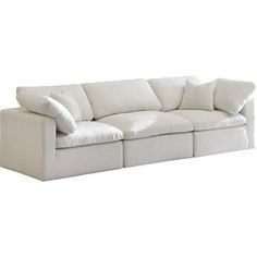 a white couch with four pillows on it's back and one arm facing the camera