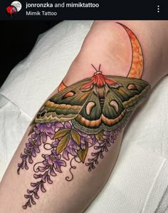 a moth tattoo on the arm with purple flowers and an orange moon in the background