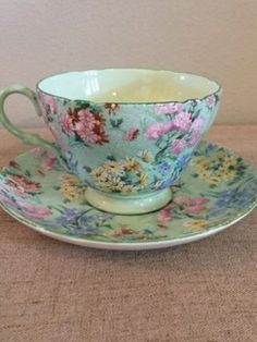 a tea cup and saucer sitting on a table