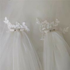 two white dresses with bows and lace on them