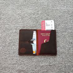 a passport case sitting on top of a carpeted floor next to a red card holder