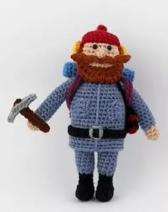 a crocheted toy is holding a hammer