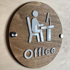 a sign that says office with a person sitting at a desk