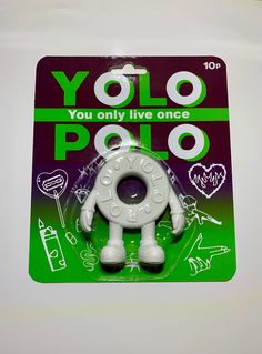 the toy is white and green with black letters on it's back side, which reads yolo poloo you only live once