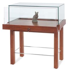 a small wooden table with a glass top on one side and a drawer on the other