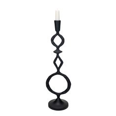 a black candle holder with a white candle in it's center and an intricate design on the base