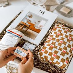 a person is holding an item in their hand near some other items on the table