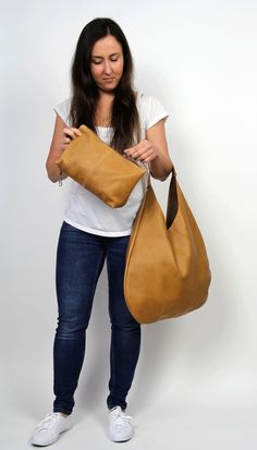 Tan hobo bag made from high quality soft and supple cowhide leather. The hobo bag can be worn as a shoulder bag . Spacious interior provides room for all the daily essentials and more. Height from top of handle to base: 66cm (26inches) Width at widest point : 49cm (19,2inches) * Includes internal pockets for mobile phone and other small items * Cosmetic bag * Top closure magnet for security To return to my shop, simply click here: https://www.etsy.com/shop/COMBAG Everyday Camel Hobo Bag With Removable Pouch, Camel Soft Leather Hobo Satchel Bag, Camel Soft Leather Satchel Hobo Bag, Versatile Brown Hobo Bag With Smooth Grain, Camel Soft Leather Hobo Bag, Versatile Brown Smooth Grain Hobo Bag, Camel Leather Hobo Shoulder Bag, Camel Soft Leather Hobo Bag For Everyday Use, Camel Leather Hobo Bag With Large Capacity