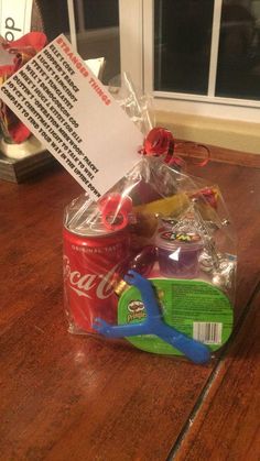 a soda can, scissors and some candy on a table with a note attached to it