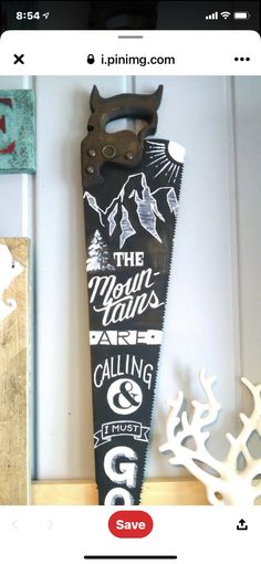 a pair of scissors is hanging on the wall next to a sign that says the mountains are calling and go