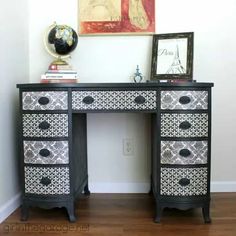 an ornate black and white desk with drawers on it's sides in front of a painting