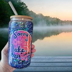 a person holding up a cup with the words sorry can't lake blvd on it