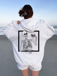 "Y2K Skeleton Hoodie Horror Hoodie Skull Hoodie Goth Hoodie Halloween Hoodie Halloween Sweaters Halloween Shirt Halloween Sweater ➭ How to Order 1. Choose your sweatshirt size & color options. 2. Select the quantity. 3. Click \"Add to Cart.\" 4. Listen for a knock at your door! ➭ Care Instructions Wash your shirt in warm water. Bleach if needed. Do not dry clean or iron directly on the design. Tumble dry on medium. ➭ Production & Shipping Processing typically takes 1-3 days. Depending on where y Oversized Hip Hop Hoodie For Halloween, White Punk Hooded Hoodie, White Hooded Punk Hoodie, White Punk Hoodie, Punk Halloween Hoodie Sweatshirt, Oversized Hooded Skull Print Sweatshirt, Oversized Hooded Sweatshirt With Skull Print, Punk Halloween Hoodie With Skull Print, Punk Skull Hoodie For Halloween