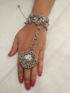 a woman's hand is adorned with silver jewelry