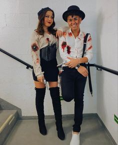 two people dressed up as zombies posing for a photo on the stairs with their arms around each other