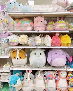 many stuffed animals are on shelves in a store