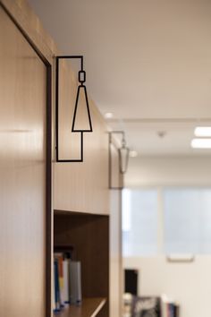 a book shelf with some books on it and a lamp hanging from the wall above