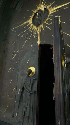 the door is open and there are two statues in front of it that have gold sprinkles on them