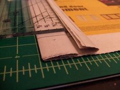 a pair of scissors laying on top of a piece of paper next to a ruler