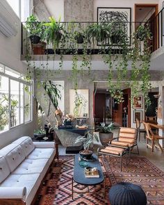 a living room filled with furniture and lots of plants