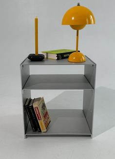 a yellow lamp sitting on top of a metal shelf