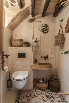 a bathroom with a toilet, sink and hanging baskets