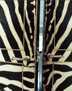 two zebra print doors with metal handles and rivets on each side, both open