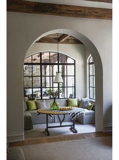 a living room filled with furniture and lots of windows in the wall next to a couch