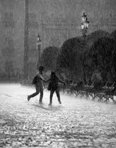 two people walking in the rain holding hands